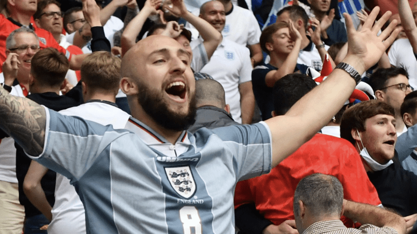 England fan enthusiastically cheering at a sports event, wearing team colors, capturing the spirit of national pride
