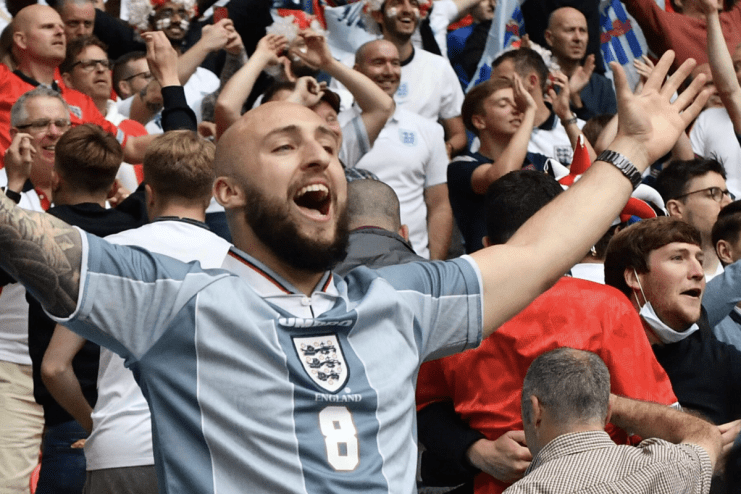 England fan enthusiastically cheering at a sports event, wearing team colors, capturing the spirit of national pride