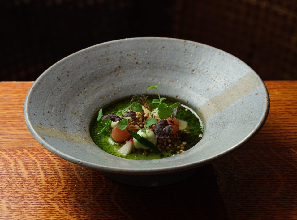 Hamachi peach nimbu pani garnished with fresh mint leaves in a clear glass on a wooden table, captured by Anton Rodriguez