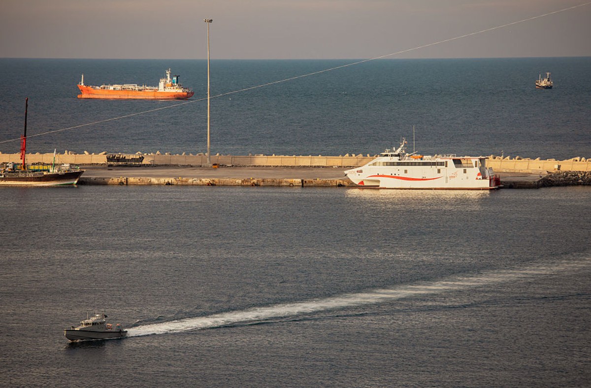 Bustling shipping activity in the Strait of Hormuz with tankers and cargo ships navigating Iranian waters.