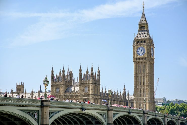 Houses of Parliament in Westminster showcasing historic architecture under a clear sky, central to UK government and politics