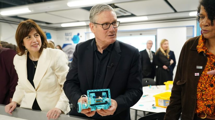Keir Starmer visiting a local school, engaging with students and staff in a classroom setting, emphasizing education prior...