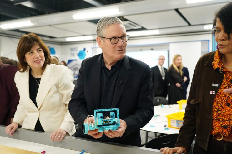 Keir Starmer visiting a local school, engaging with students and staff in a classroom setting, emphasizing education prior...
