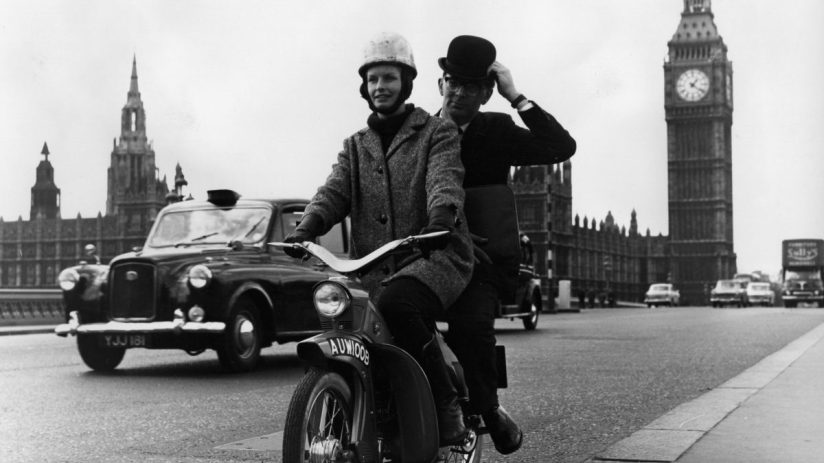 Moped navigating busy London street, highlighting urban transportation and city traffic dynamics