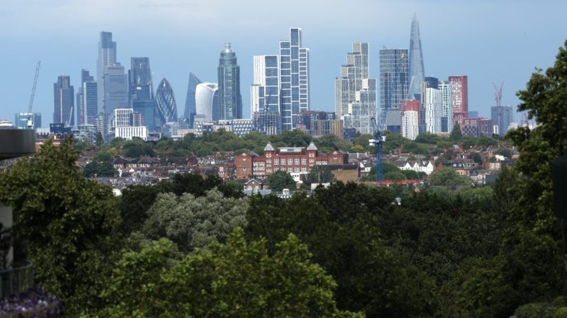 London skyline with modern skyscrapers and lush green foliage in foreground on a clear day, highlighting urban nature balance