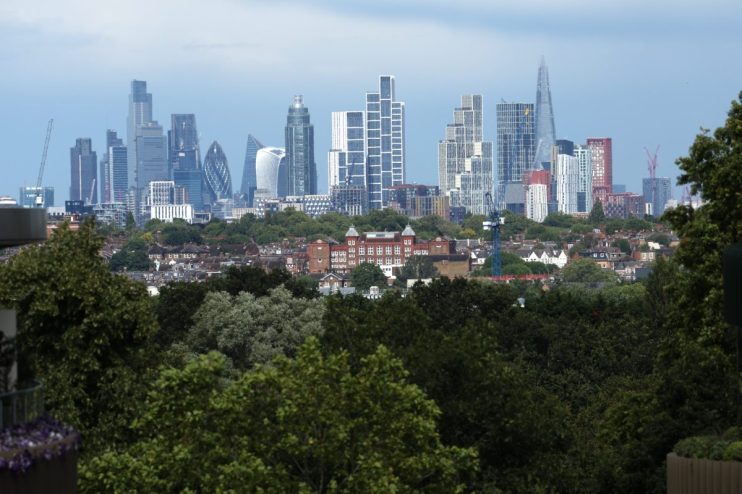 London skyline with modern skyscrapers and lush green foliage in foreground on a clear day, highlighting urban nature balance