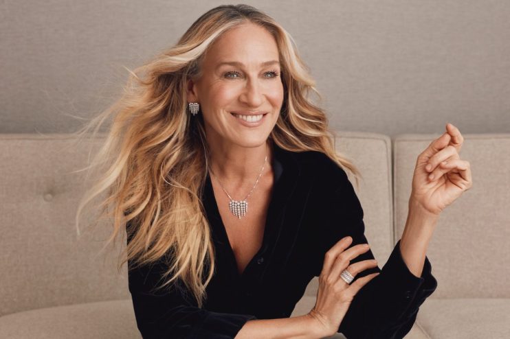 Sarah Jessica Parker at a public event, wearing a stylish outfit, engaging with fans and media in a vibrant city setting
