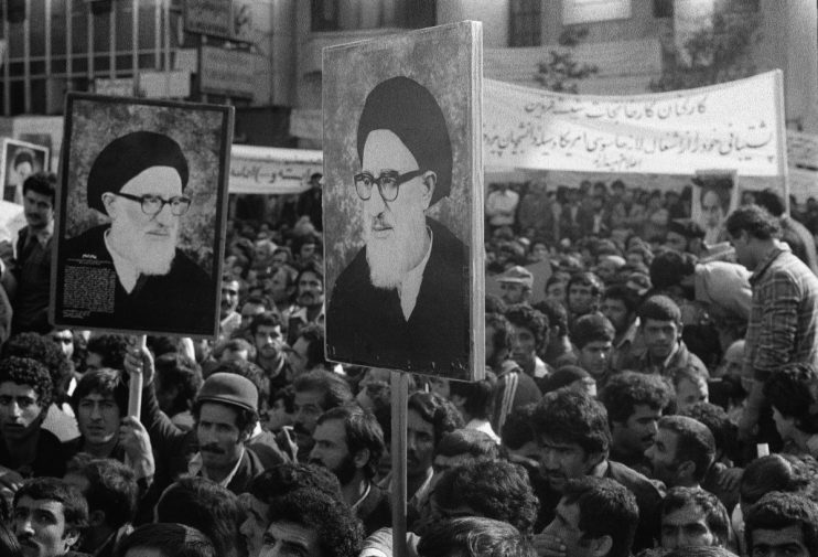 Tehran embassy siege showing armed forces surrounding the building with crowds gathered outside in tense standoff