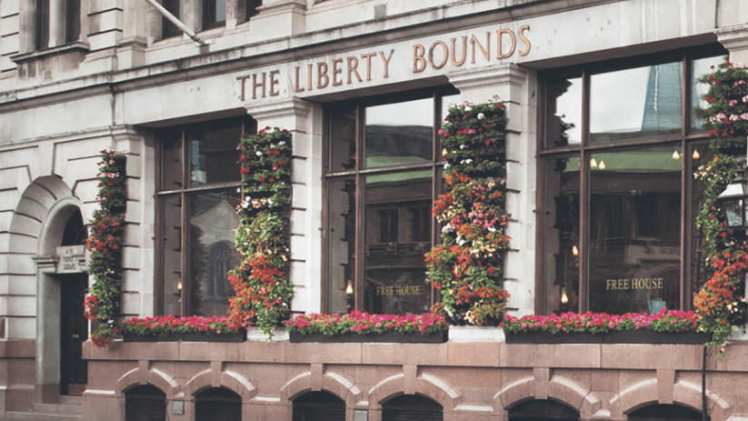 The Liberty Bounds Wetherspoons pub exterior with patrons and bustling street scene in central London