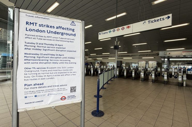 Crowded London Underground platform during tube strike with passengers waiting for limited train service amidst travel dis...