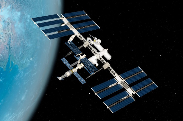 International Space Station orbiting Earth with solar panels extended against a backdrop of stars and the blue planet below