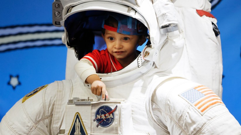 Astronaut floating in space with Earth visible in the background, highlighting the vastness of the universe and human expl...