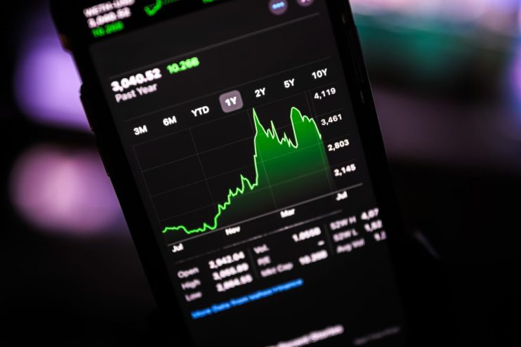 Graph showing fluctuating stock prices with green and red arrows indicating market trends on financial news website