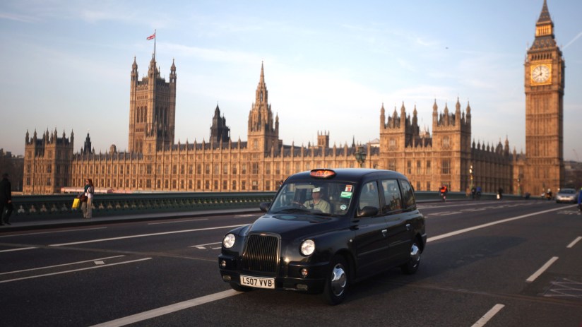 London black taxi cab driving through city streets, representing urban transportation and iconic British travel scene