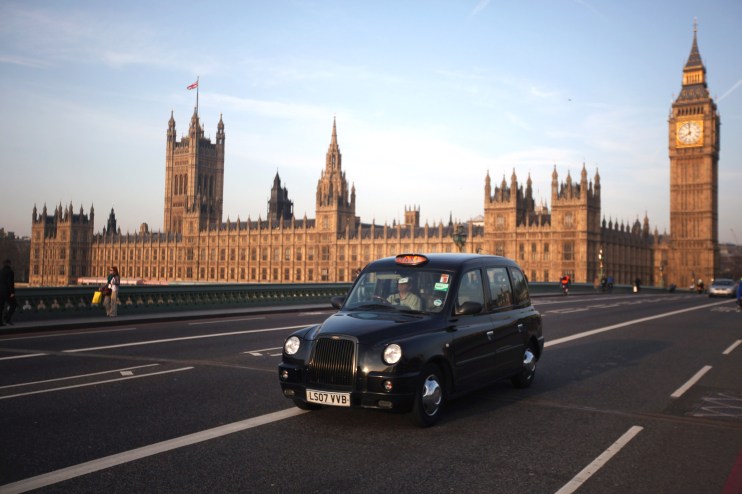 London black taxi cab driving through city streets, representing urban transportation and iconic British travel scene