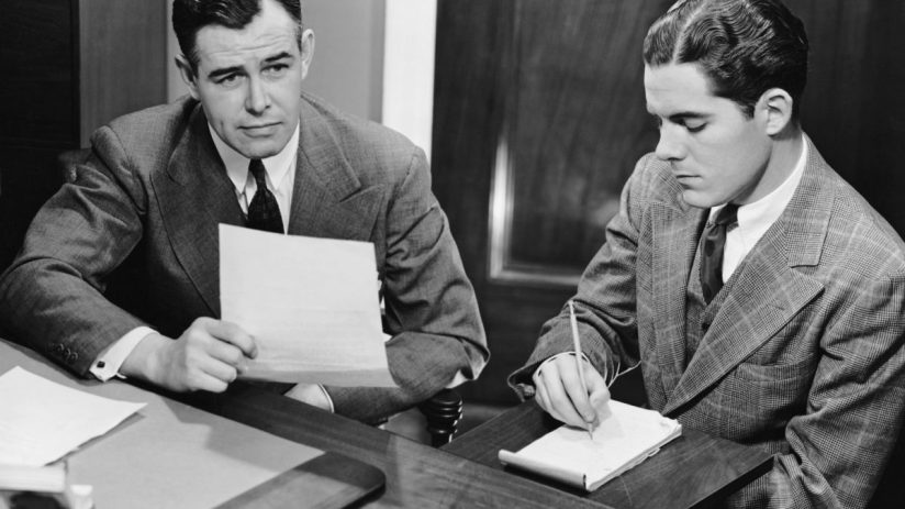 Office workers collaborating at desks, engaging in teamwork and discussions, enhancing productivity in a modern business e...