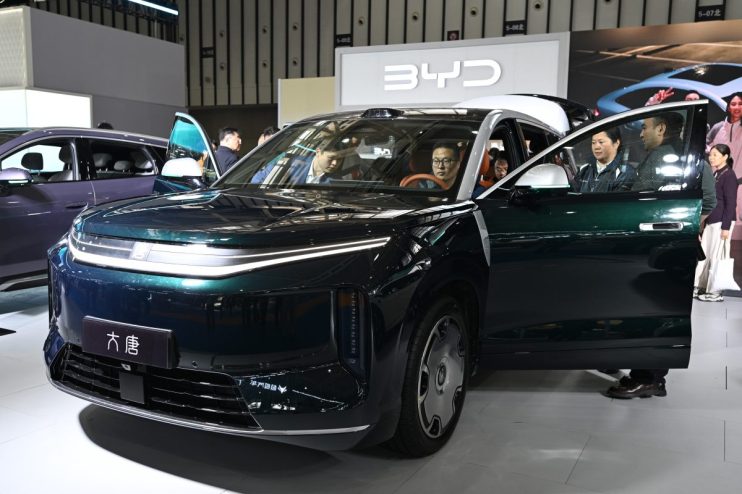 BYD electric vehicle displayed at an auto show featuring sleek design, showcasing the latest in green automotive technology