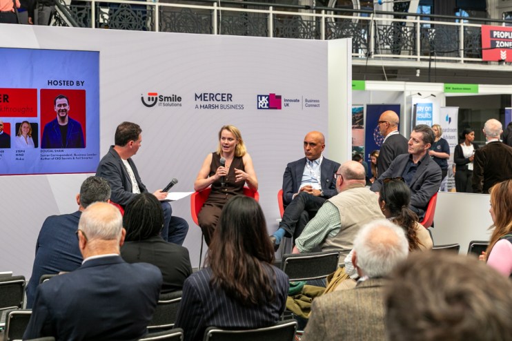 Dougal Shaw, Steph Hind, Gurinder Dhillon, and John Stapleton speaking on stage at SCALE 2 business event