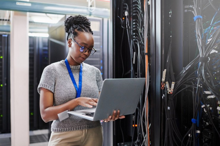 IT professional managing server room equipment with focus on advanced technology and network infrastructure
