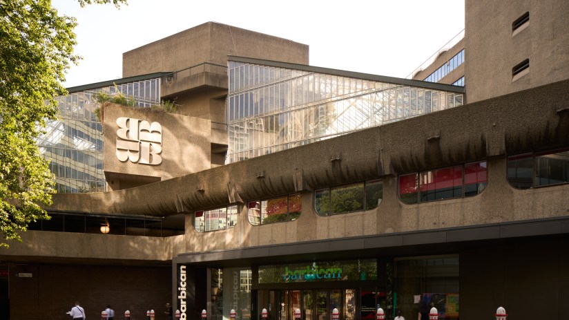 Barbican Centre exterior showcasing iconic brutalist architecture on a sunny day with people walking in the foreground