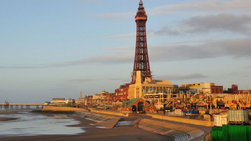 Blackpool skyline at sunset with iconic tower and bustling promenade, highlighting vibrant seaside town atmosphere