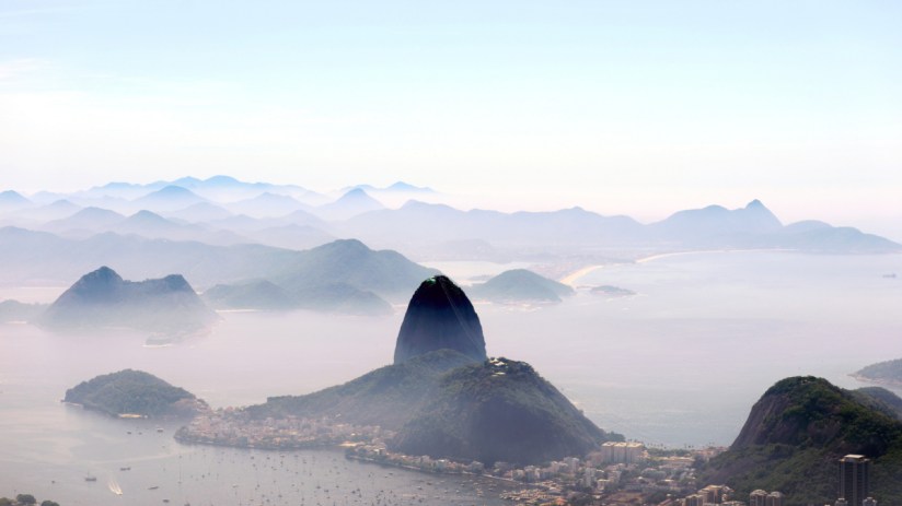Aerial view of Brazils vibrant cityscape with iconic landmarks and lush greenery under a clear blue sky