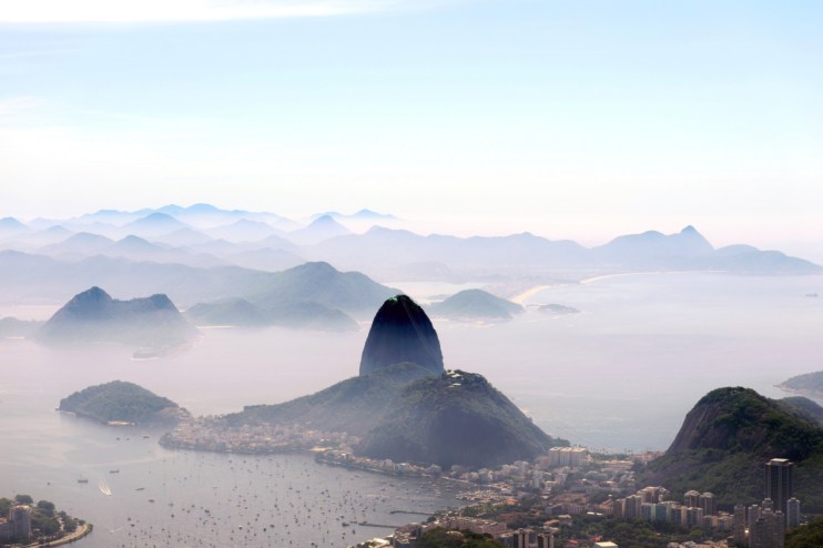 Aerial view of Brazils vibrant cityscape with iconic landmarks and lush greenery under a clear blue sky
