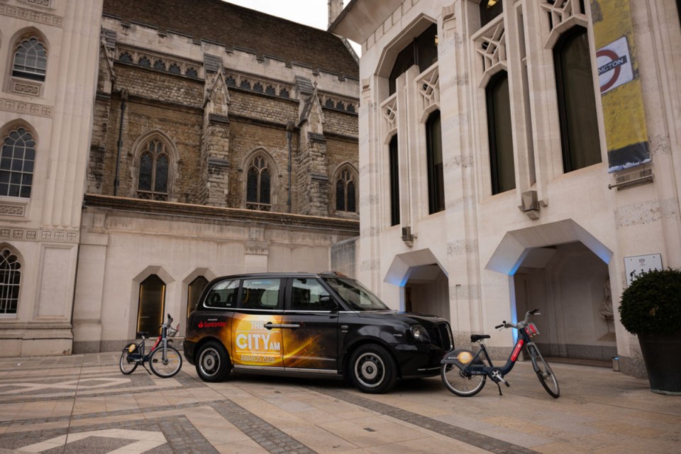 Taxi arriving at Morning Wire Awards venue with illuminated city skyline in the background, highlighting urban business excellence