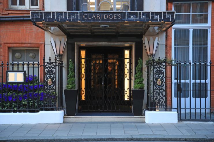 Claridges Hotel exterior showcasing elegant architecture with iconic entrance in a bustling city environment.