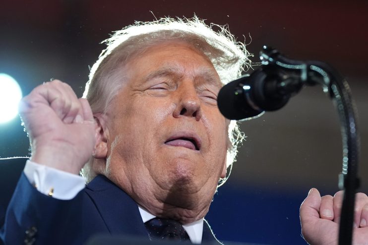 Donald Trump discussing the Iran nuclear deal, standing at a podium with the American flag in the background