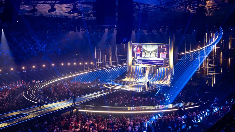 Eurovision stage with vibrant lights and performers captivating an enthusiastic audience during the live music competition.