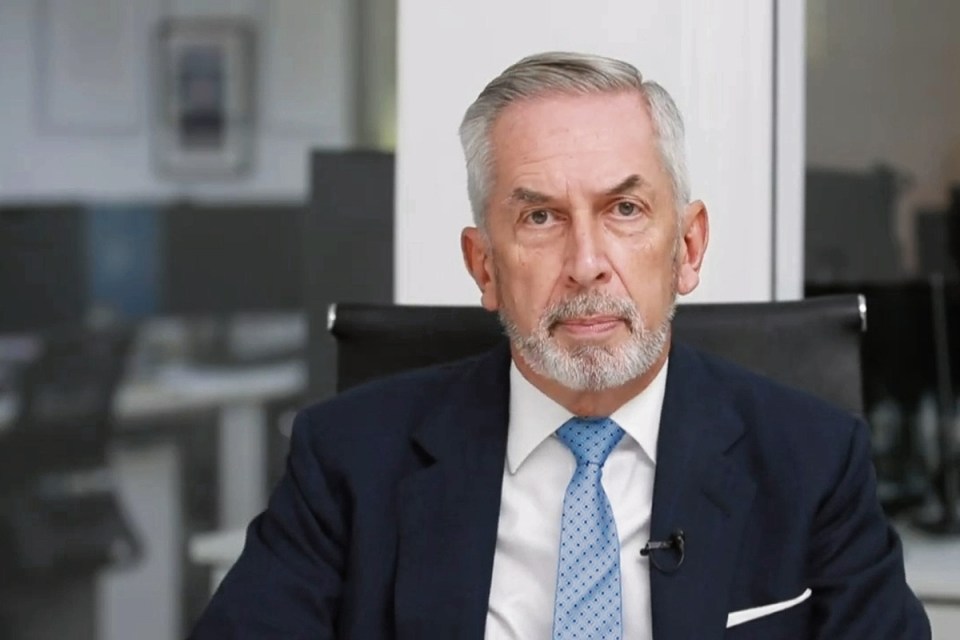 Terry Smith, founder of Fundsmith, speaking at a business conference, wearing a suit and tie, with a focused expression.