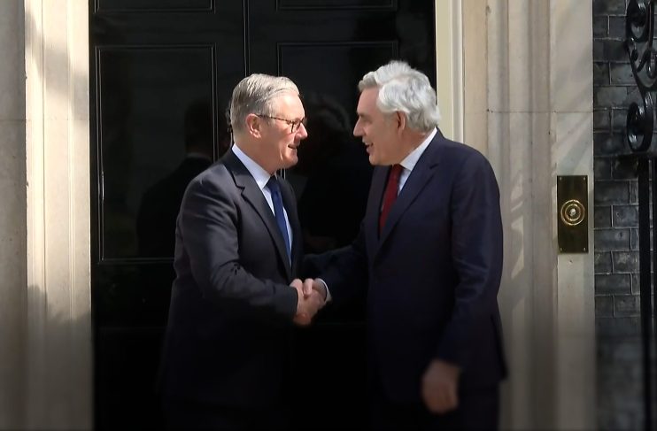 Gordon Brown and Keir Starmer engaged in discussion at a political event, highlighting leadership and policy collaboration