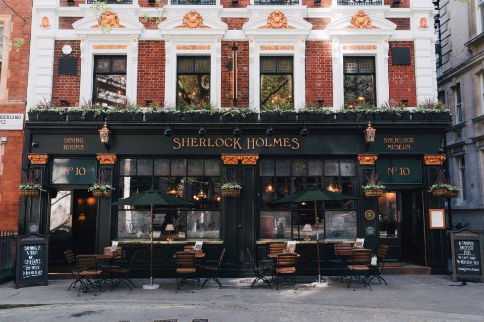Greene King pub exterior with patrons enjoying outdoor seating on a sunny day, highlighting the venues lively atmosphere.