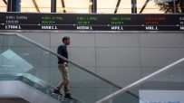 Traders analyzing data on screens at London Stock Exchange, showcasing investment trends and market activity