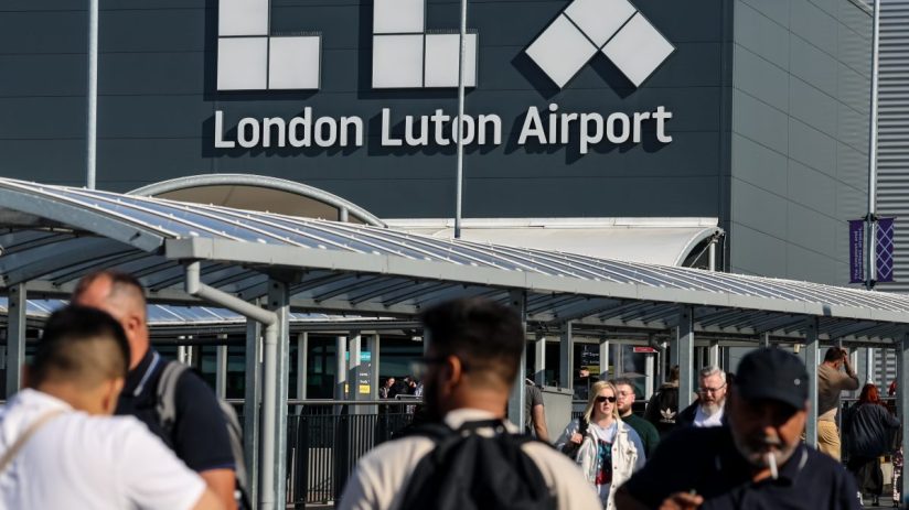Luton Airport aerial view with planes, runways, and terminal buildings, highlighting busy travel hub operations