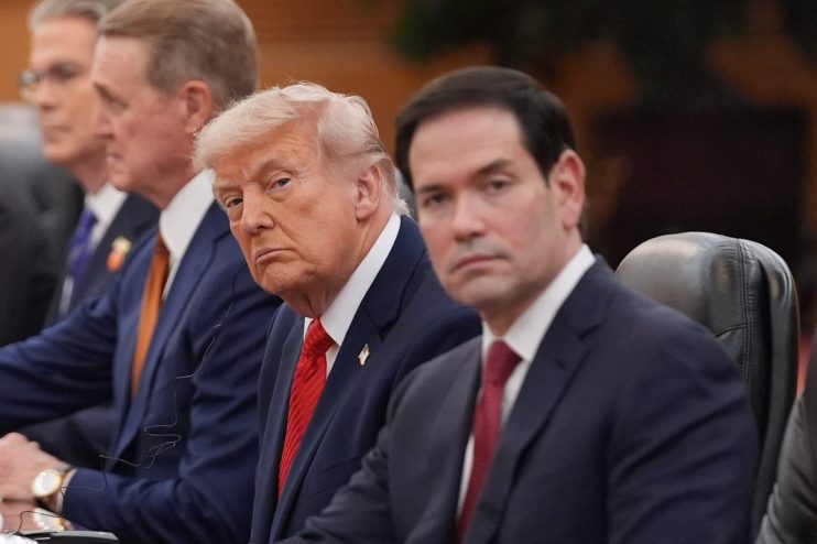 Marco Rubio and Donald Trump engaged in conversation at a political event, highlighting their policy discussions and inter...