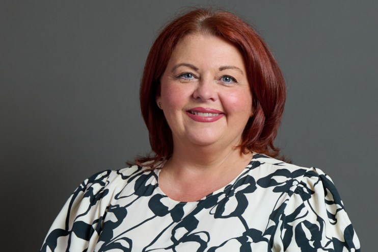 Paula Barker speaking on bond markets aligning with Andy Burnhams economic views, addressing audience at conference.