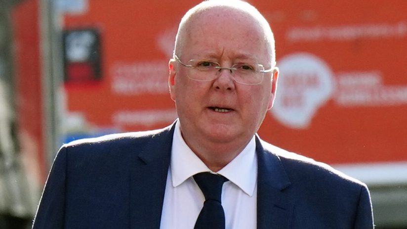 Peter Murrell at a press conference, addressing the media with a focused expression against a backdrop of journalists and ...