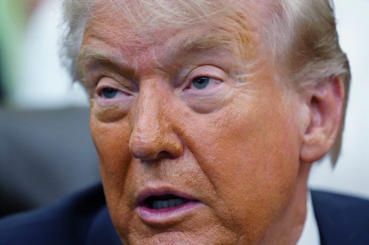 President Trump delivering a statement on the Iran conflict in a formal press conference setting