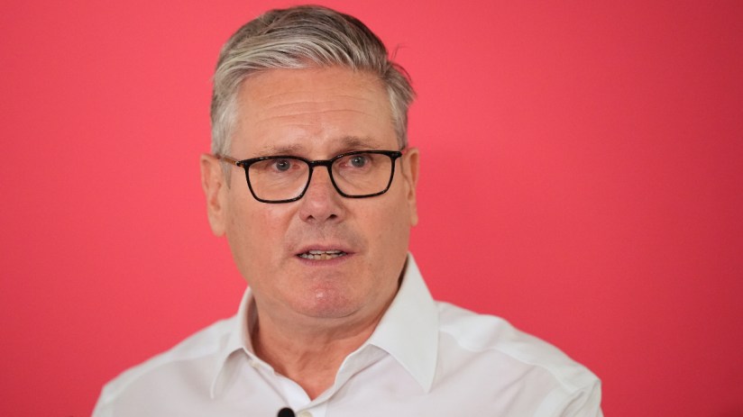 Prime Minister Keir Starmer speaks at a press conference addressing future leadership rumours, wearing a navy suit and tie.