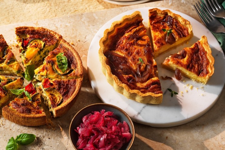 Golden-brown homemade quiche with flaky crust and vibrant vegetable filling, freshly baked and ready to serve.