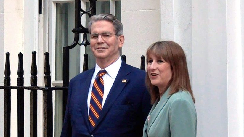 Scott Besent and Rachel Reeves discussing economic strategies at a business conference podium