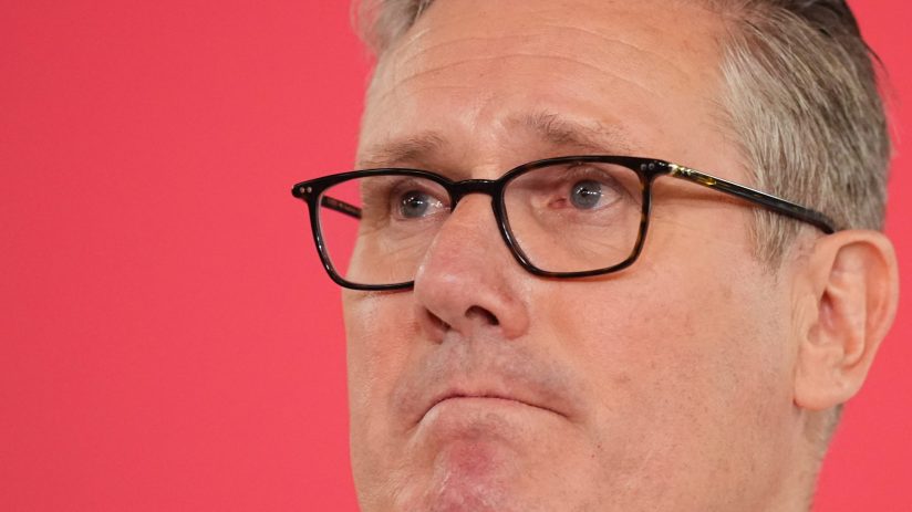 Sir Keir Starmer standing resolute, addressing media amid political pressure, refusing resignation calls in a formal setting