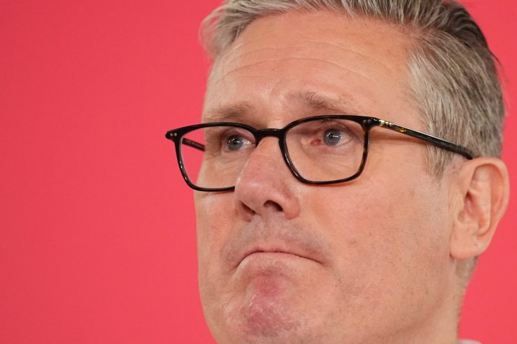 Sir Keir Starmer standing resolute, addressing media amid political pressure, refusing resignation calls in a formal setting