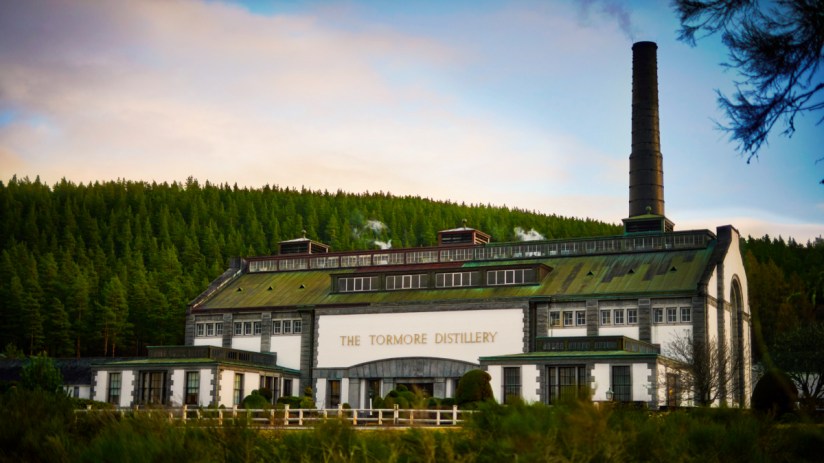 Tormore Distillery in scenic Speyside, showcasing traditional architecture with whisky barrels and lush greenery in the fo...