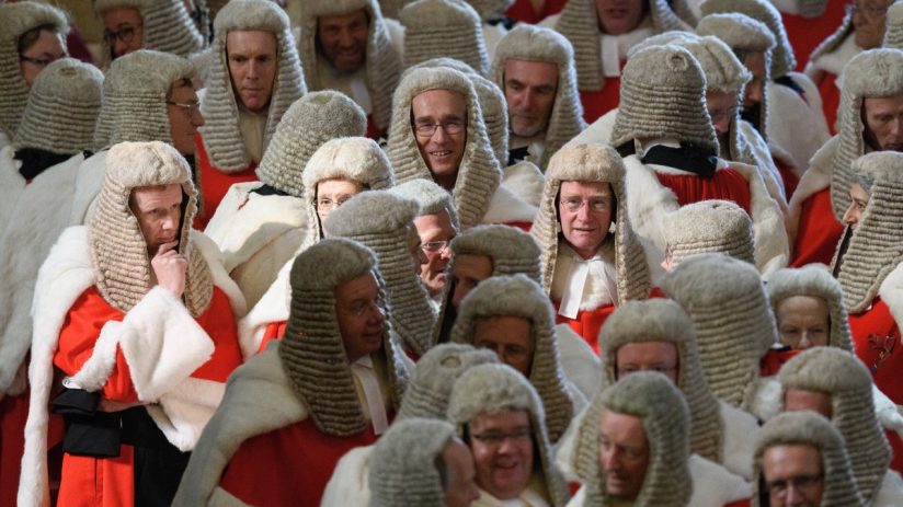 UK court judges in traditional robes and wigs seated in a courtroom, discussing important legal proceedings.