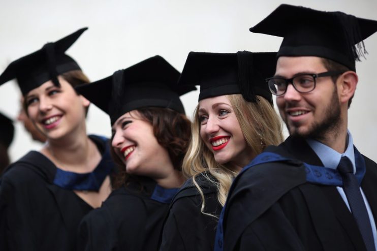Young UK graduates from Gen Z celebrating in caps and gowns, representing the future workforce and educational achievements.