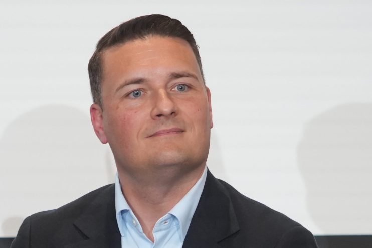 Wes Streeting speaking at a podium with a Labour Party banner, potential future Labour leader, addressing a crowd
