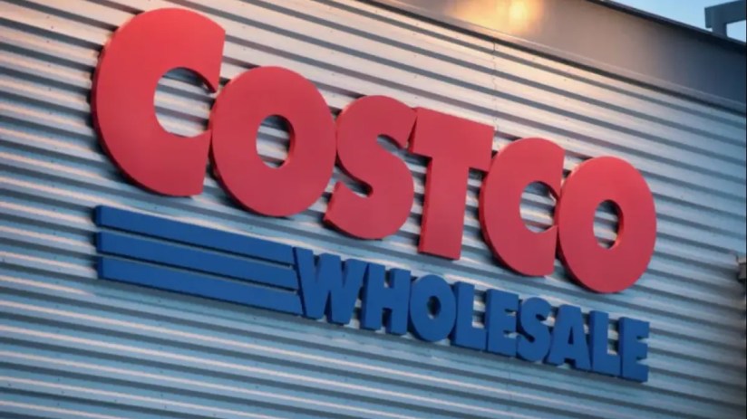 Costco storefront with customers entering and exiting, showcasing the bustling atmosphere of a popular retail warehouse chain